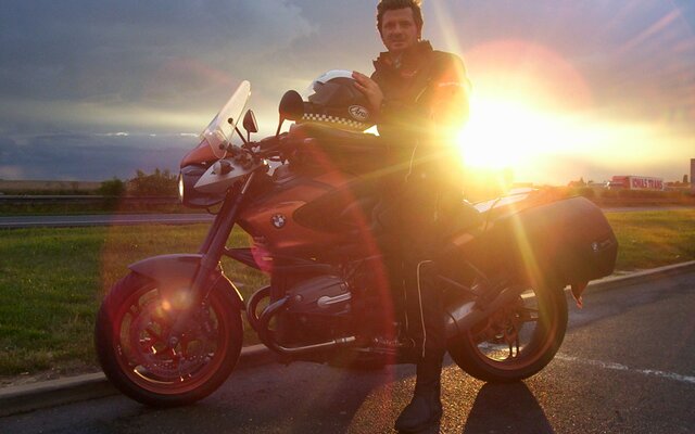 Biker mit seinem Motorrad vor dem Sonnenuntergang